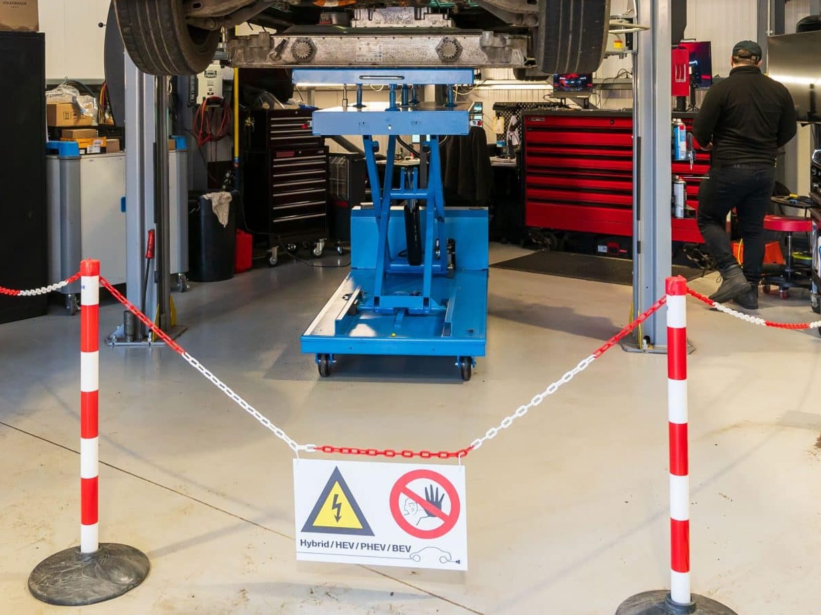 The high-voltage safe working zone at Stedmans Garage in Worthing, barriers up and battery support table in place during an EV repair