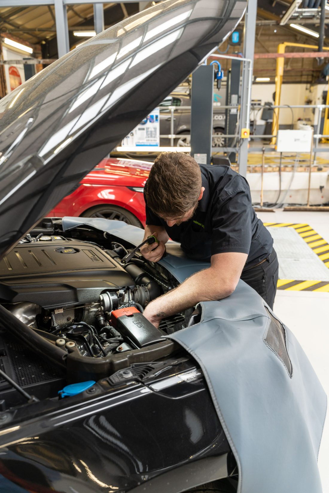 A Stedmans Garage technician working under the bonnet of a car