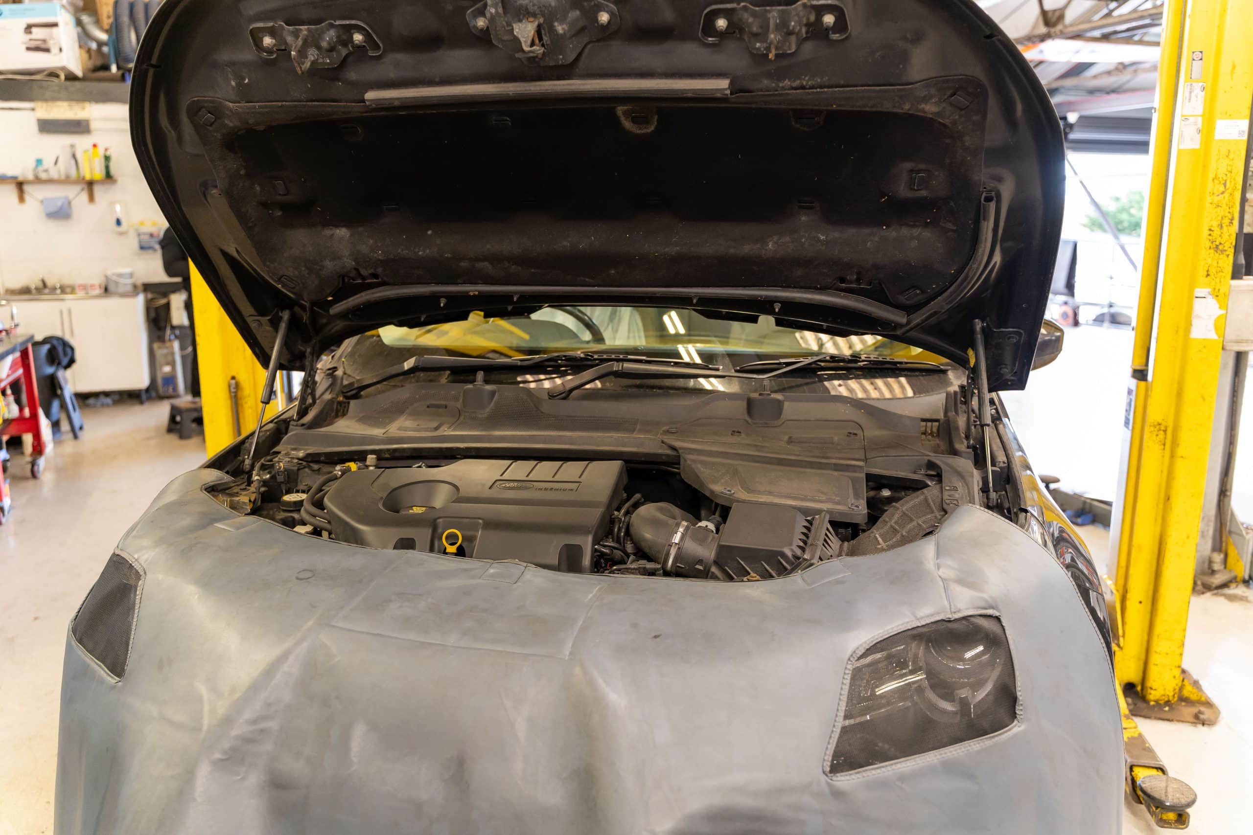 A technician servicing a car in the workshop at Stedmans Garage in Worthing